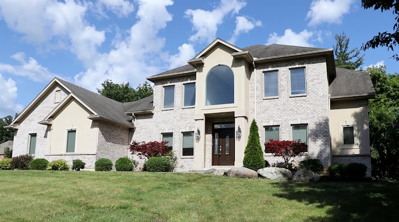 Soaring ceilings, oversized built-in artwork nooks, Brazilian hardwood floors and a curved staircase with wrought iron and gold accents are just some of the details of this 2-story. The brick house has a first-floor main bedroom and a finished basement with media room. CONTRIBUTED PHOTO BY KATHY TYLER