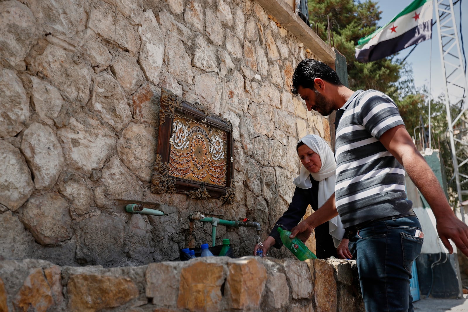 Visitors fill bottles with water from the spring in Ein el-Fijeh, Barada Valley, Syria, Thursday, May 8, 2025. The Ein el-Fijeh spring, the main source of water for Damascus, is almost dry and many people in the capital and its suburbs are now relying on buying water from tanker trucks that fill from wells. (AP Photo/Omar Sanadiki)