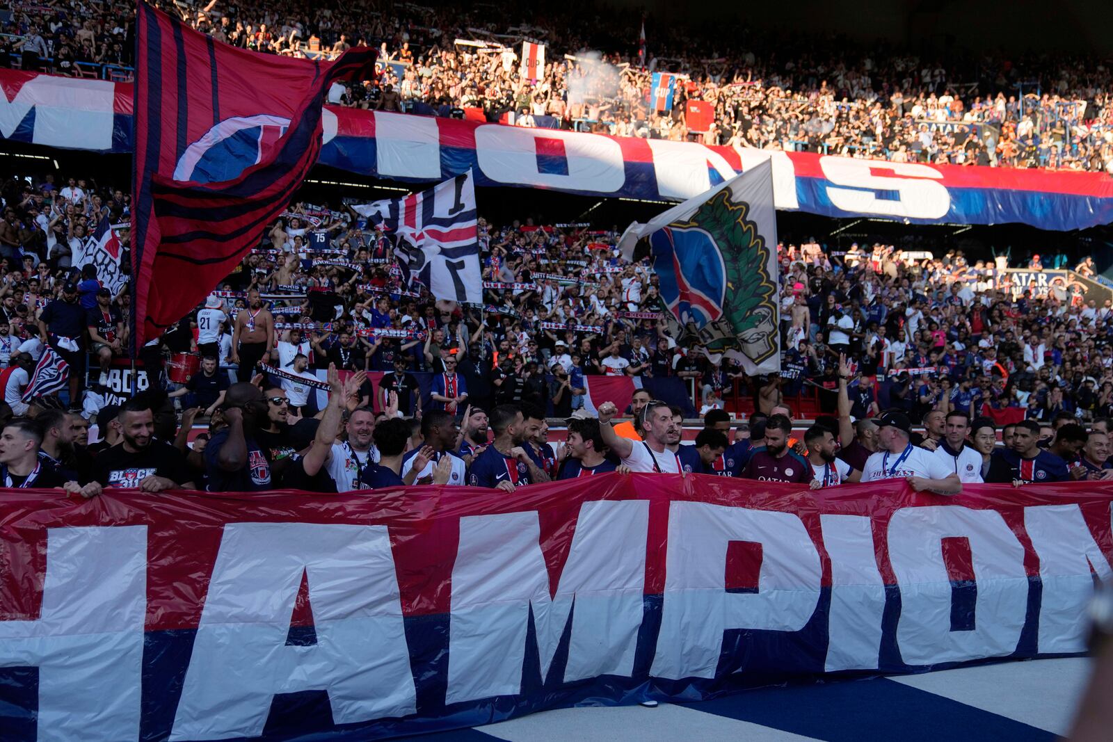 PSG's supporters celebrate winning the French League One championship title after the soccer match between Paris Saint-Germain and Angers at Parc des Princes stadium in Paris, Saturday, April 5, 2025. (AP Photo/Michel Euler)
