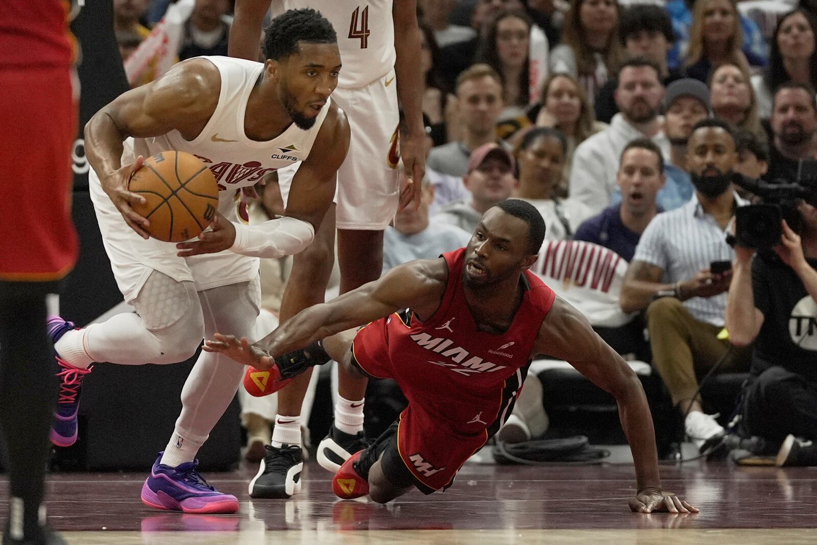 Miami Heat forward Andrew Wiggins, right, reaches for the ball as Cleveland Cavaliers guard Donovan Mitchell (45) heads up the court in the second half in Game 1 of an NBA first-round playoff series, Sunday, April 20, 2025, in Cleveland. (AP Photo/Sue Ogrocki)