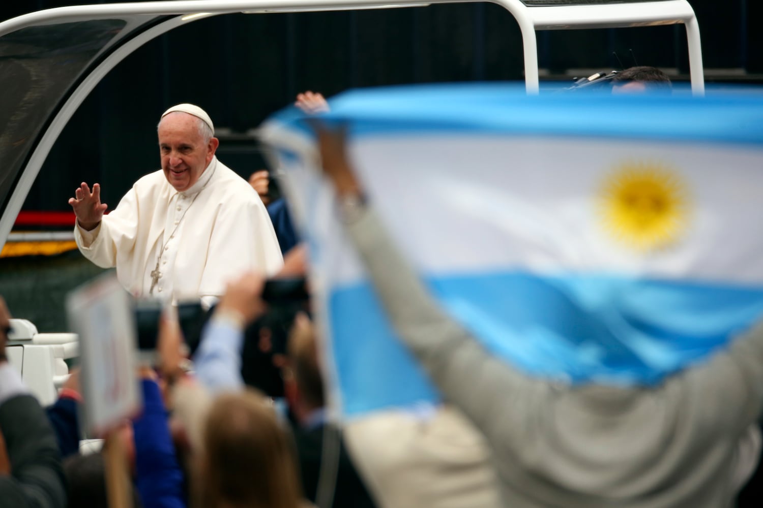 FILE Ñ A well-wisher holds up the flag of Argentina, the homeland of Pope Francis, as the pontiff greets the crowd before celebrating an open-air Mass on the Benjamin Franklin Parkway in Philadelphia on Sept. 27, 2015. (Damon Winter/The New York Times)