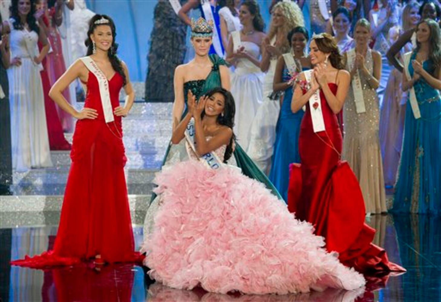 Miss Venezuela, Ivian Sarcos, seated, surrounded by Miss Philippines, Gwendoline Ruais, left, Miss Puerto Rico, Amanda Perez, right, as she's crowned by former Miss World Alexandria Mills