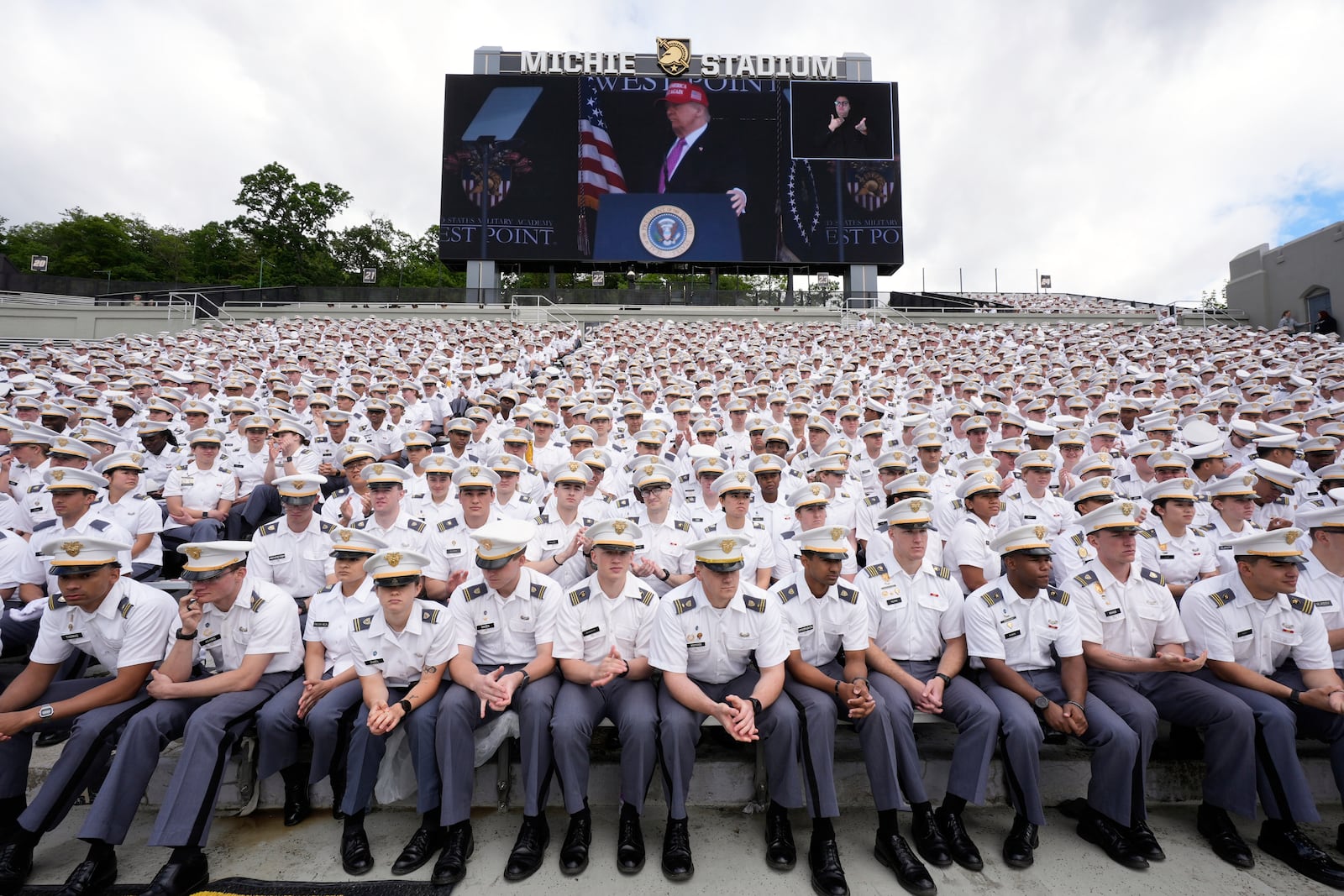 Cadets listen as President Donald Trump, seen on screen, speaks to United States Military Academy graduating cadets during commencement ceremonies in West Point, N.Y., Saturday, May 24, 2025. (AP Photo/Manuel Balce Ceneta)