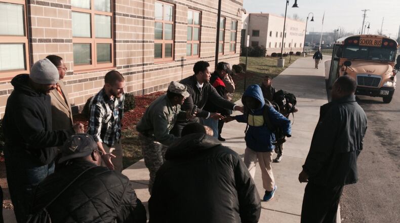 Dozens of men greet students with cheers as they arrive at Dayton Boys Prep Academy during a Men of Color day that brought more than 200 black male role models into public schools. JEREMY P. KELLEY / STAFF