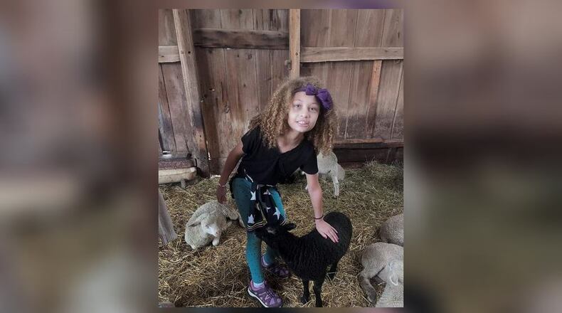 Pamela’s daughter Jasmine makes a furry friend during a summer visit to The Learning Tree Farm. PAMELA CHANDLER/CONTRIBUTED