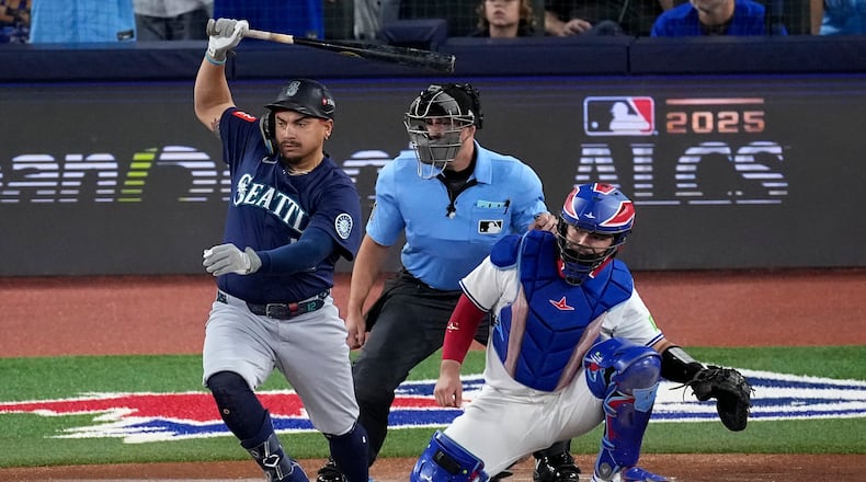 Seattle Mariners' Josh Naylor follows through on an RBI base hit off Toronto Blue Jays pitcher Shane Bieber (57) during the first inning in Game 7 of baseball's American League Championship Series, Monday, Oct. 20, 2025, in Toronto. (AP Photo/David J. Phillip)