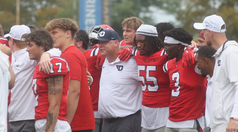 Dayton players and coach Trevor Andrews celebrate a victory against St. Francis on Saturday, Aug. 31, 2024, at Welcome Stadium in Dayton. David Jablonski/Staff
