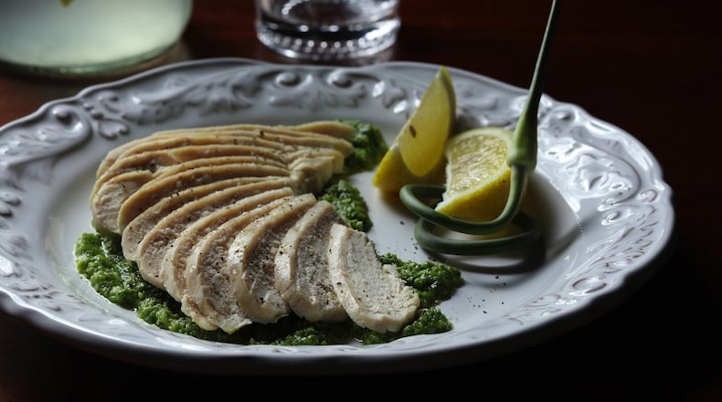Garlic scapes, the stalks of a garlic plant, make a powerful pesto that serves as a bed for gently dry-poached chicken. Joan Moravek / food styling (Abel Uribe/Chicago Tribune/TNS)