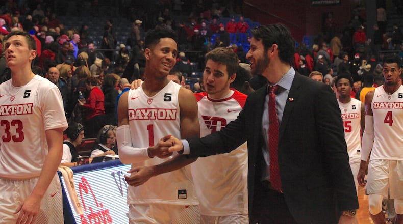Dayton players and coaches leave the court after a victory Saturday over East Tennessee State. David Jablonski/Staff