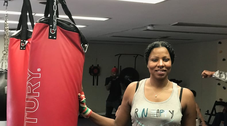 Chia Fei before she starts working on the heavy bag a few evenings ago at the King of Kingz gym in Cincinnati. The 42-year-old mother of three – a product of Belmont High and Sinclair Community College who now lives in Kettering – has had three pro bouts, all on the road, Her hometown debut is scheduled for October 19 at a gala show at the Flyght Academy in Trotwood. Tom Archdeacon/CONTRIBUTED