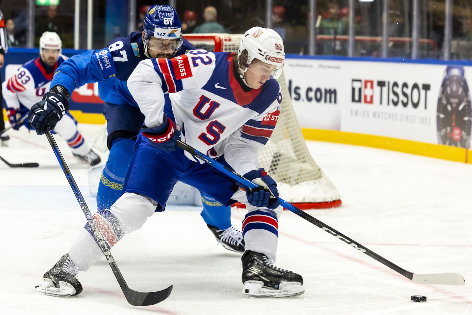 Kazakhstan's defender Adil Beketayev, left, vies for the puck with USA's forward Logan Cooley, right, during the IIHF 2025 World Championship preliminary round group B game between Kazakhstan and USA, at the Jyske Bank Boxen, in Herning, Denmark, Sunday, May 18, 2025. (Salvatore Di Nolfi/Keystone via AP)
