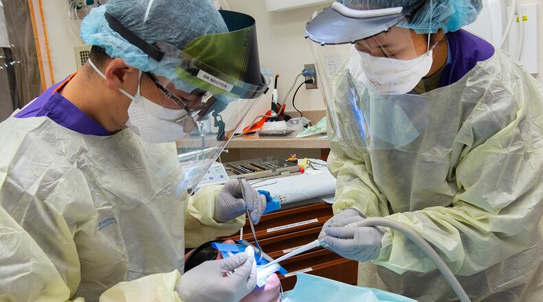 Airman 1st Class Gaudley Peji (right), 88th Dental Squadron dental assistant, works with Capt. Daniel Nguyen, 88 DS dental resident, during a procedure in the dental clinic at Wright-Patterson Air Force Base on Feb. 22. The Wright-Patt clinic observed Dental Assistants Recognition Week the first week of March. U.S. AIR FORCE PHOTO/R.J. ORIEZ