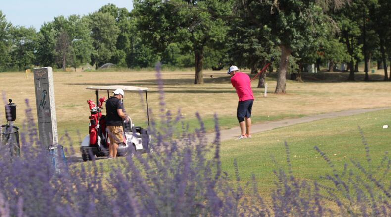 Players are shown at Kittyhawk Golf Center, part of Dayton’s golf system. CORNELIUS FROLIK / STAFF