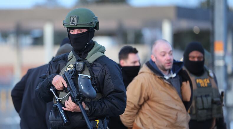 Protesters are arrested by federal agents outside the Bishop Henry Whipple Federal Building in Minneapolis, Friday, Jan. 9, 2026. (AP Photo/Adam Bettcher)