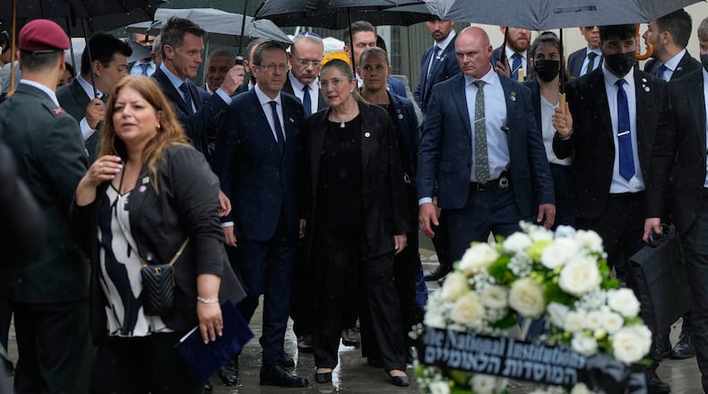 Israel's President Isaac Herzog, center left, and his wife Michal Herzog, center right, arrive at Bondi Beach for a memorial of the Dec. 2025 shooting victims, in Sydney, Monday, Feb. 9, 2026. (AP Photo/Rick Rycroft)