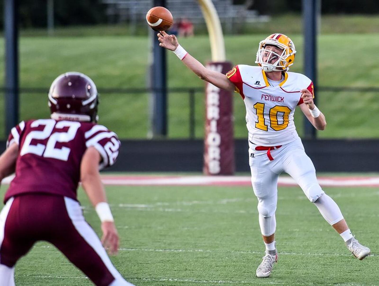 Fenwick quarterback Sully Janeck throws on the run as Lebanon’s Noah Schneider (22) defends during a 49-27 win for the host Warriors on Sept. 8, 2017, at James VanDeGrift Stadium in Lebanon. NICK GRAHAM/STAFF