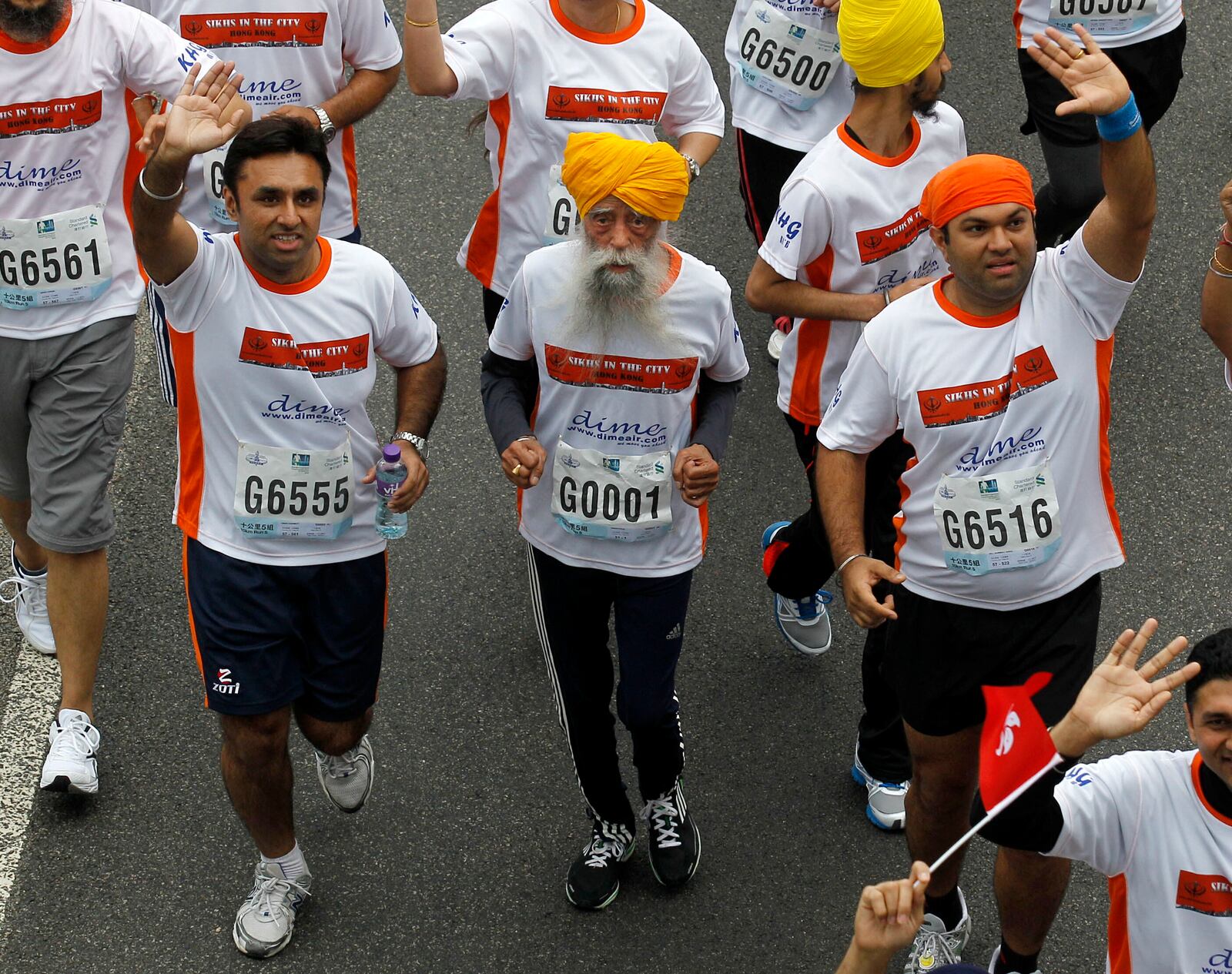 FILE - Centenarian marathon runner Fauja Singh, 101, center, originally from Beas Pind, in Jalandhar, India but who now lives in London, runs in a 10-kilometer race, part of the annual Hong Kong Marathon, in Hong Kong Sunday, Feb. 24, 2013. (AP Photo/Kin Cheung, File)