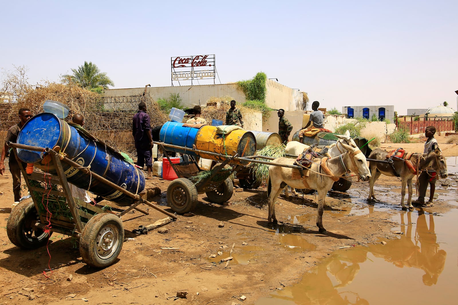 People fill water containers at a distribution point due to water outages in Khartoum, Sudan, Sunday, May 25, 2025. (AP Photo)