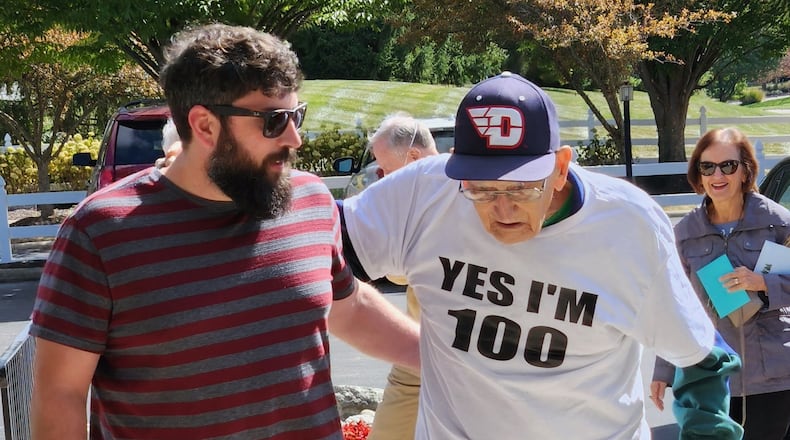 Dayton basketball fan John Mauro, right, celebrates his 100th birthday on Saturday, Oct. 8, 2022. At left is his grandson Keith Saunders, of Nashville, Tenn. Photo by Tim Grobe