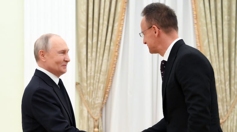 Russian President Vladimir Putin, left, and Hungarian Foreign Minister Peter Szijjarto shake hands during their meeting at the Senate Palace of the Kremlin in Moscow, Wednesday, March 4, 2026. (Grigory Sysoyev, Sputnik, Kremlin Pool Photo via AP)
