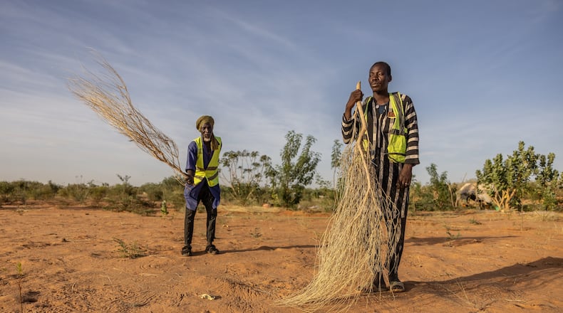 Mbera fire brigade members from the NGO SOS desert demonstrate the brushing technique used to extinguish fires in Mbera Refugee Camp, near Bassikounou, Hodh El Chargui Region, Mauritania, Saturday Nov. 8, 2025. (AP Photo/Caitlin Kelly)