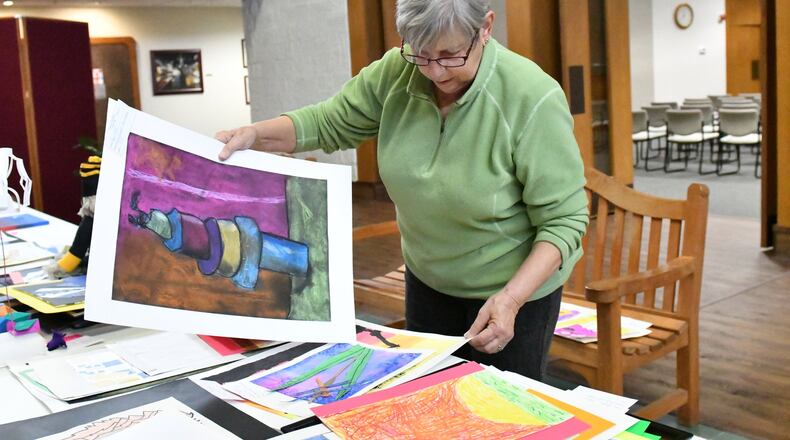 Kathleen Abraham, a volunteer, looks through artwork submitted for the annual Festival and Art Commission Youth Art Fair in Englewood. CONTRIBUTED