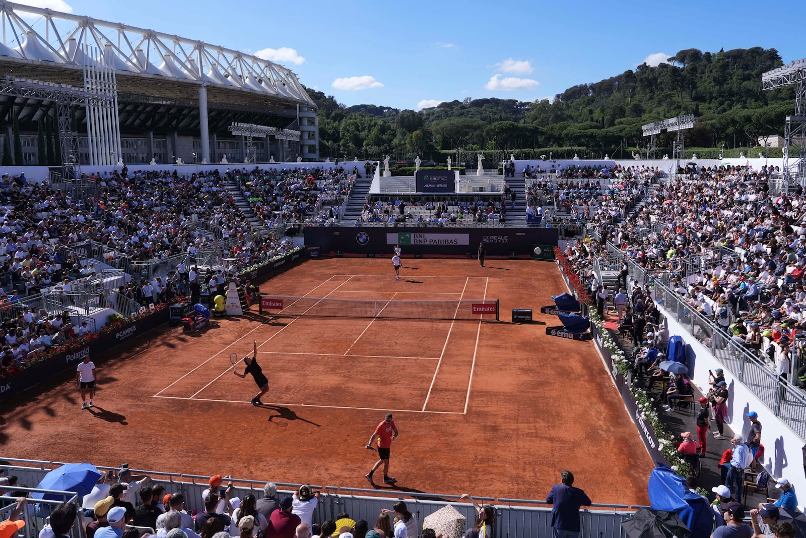 People watch a training session between Italy's Lorenzo Sonego, serving bottom, and Italy's Jannik Sinner at the Foro Italico in Rome, Italy, May 6, 2025 (Alfredo Falcone/LaPresse via AP)