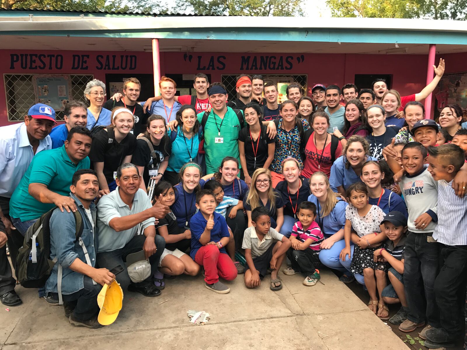 Some of the 60 University of Dayton students (with Nicaraguan community members & kids) gathered in front of the medical clinic they worked at in Las Mangas, Nicaragua in January as part of the university’s Global Brigade contingent member. CONTRIBUTED PHOTO