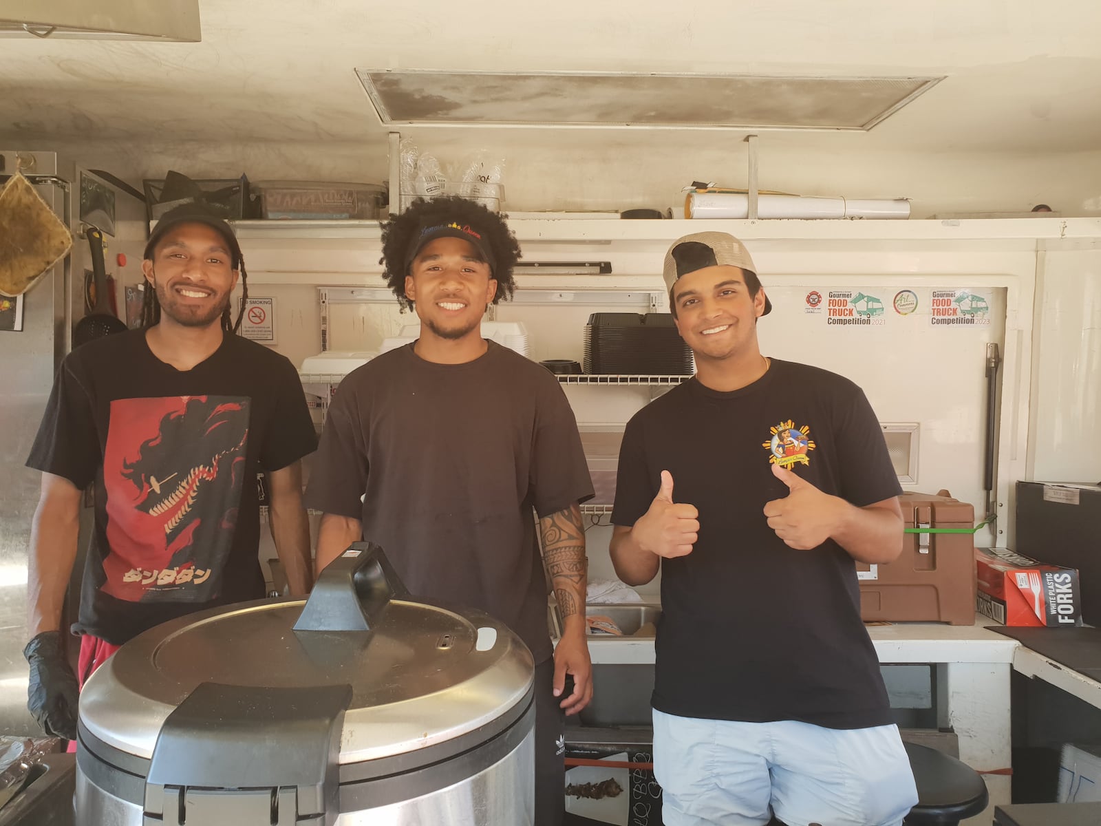 Jay Roberts (middle) and his coworkers at Lumpia Queen are ready to serve customers traditional Filipino cuisine.