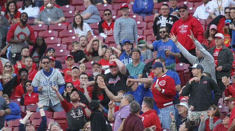 Fans try to catch a foul ball during a game between the Reds and the Cubs on Tuesday, May 14, 2019, at Great American Ball Park in Cincinnati.