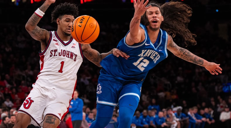 Xavier forward Tre Carroll (12) is defended by St. John's forward Dillon Mitchell (1) as he loses control of the ball during the first half of an NCAA college basketball game, Monday, Feb. 9, 2026, in New York. (AP Photo/Angelina Katsanis)