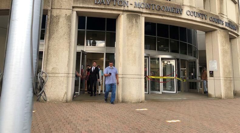 Elijah M. Rashaed, in blue, leaves Dayton Municipal Court on Wednesday. He appeared on behalf of Moonstone Investments LLC, which had a housing case dismissed after issues at a Salem Avenue apartment property were abated. CORNELIUS FROLIK / STAFF
