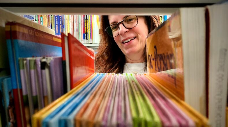 Merrell Dilsavor, a Library Aide at the Fairborn Community Library replaces books Thursday April 28, 2022. MARSHALL GORBY\STAFF