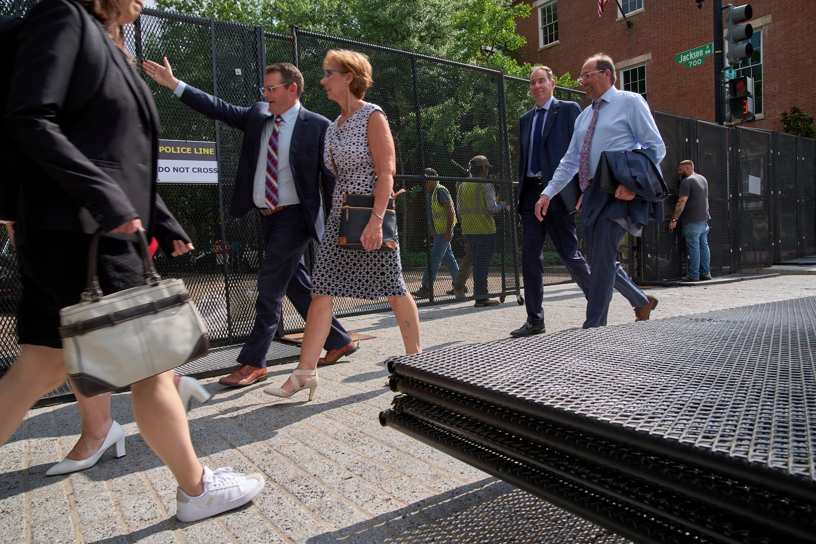 People walk by security fencing as it is installed around Lafayette Park and the White House during security preparations for a festival and parade to commemorate the 250th Birthday of the U.S. Army, Monday, June 9, 2025, in Washington. (AP Photo/Jacquelyn Martin)