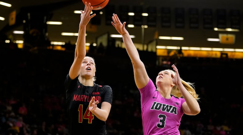 Maryland guard Taisiya Kozlova (14) drives to the basket ahead of Iowa guard Sydney Affolter (3) during the first half of an NCAA college basketball game, Monday, Feb. 14, 2022, in Iowa City, Iowa. (AP Photo/Charlie Neibergall)