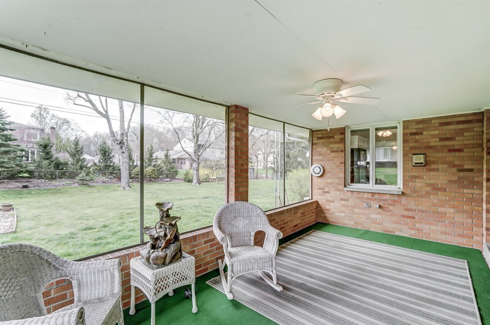 The back of the house has a screen-enclosed, three-season room and an awning-covered patio.