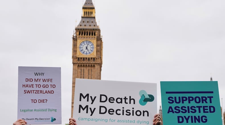 FILE - Banners are held by pro-assisted dying campaigners as they gather outside Parliament in Westminster in London, May 15, 2025. (AP Photo/Kirsty Wigglesworth, File)