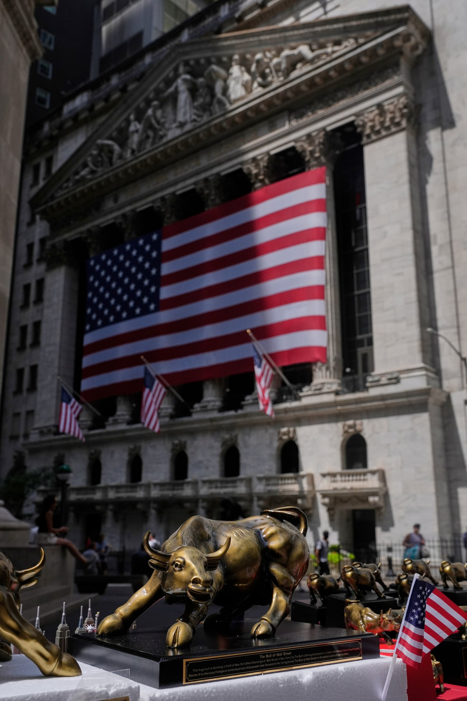 A vendor displays souvenirs on the street in front of the New York Stock Exchange in New York, Monday, July 14, 2025. (AP Photo/Seth Wenig)