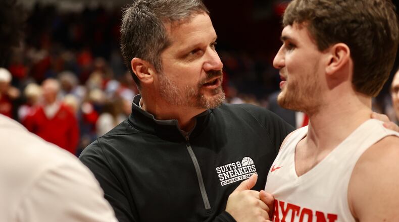Dayton trainer Mike Mulcahey and Brady Uhl leave the court after a victory against Richmond on Saturday, Jan. 28, 2023, at UD Arena. David Jablonski/Staff