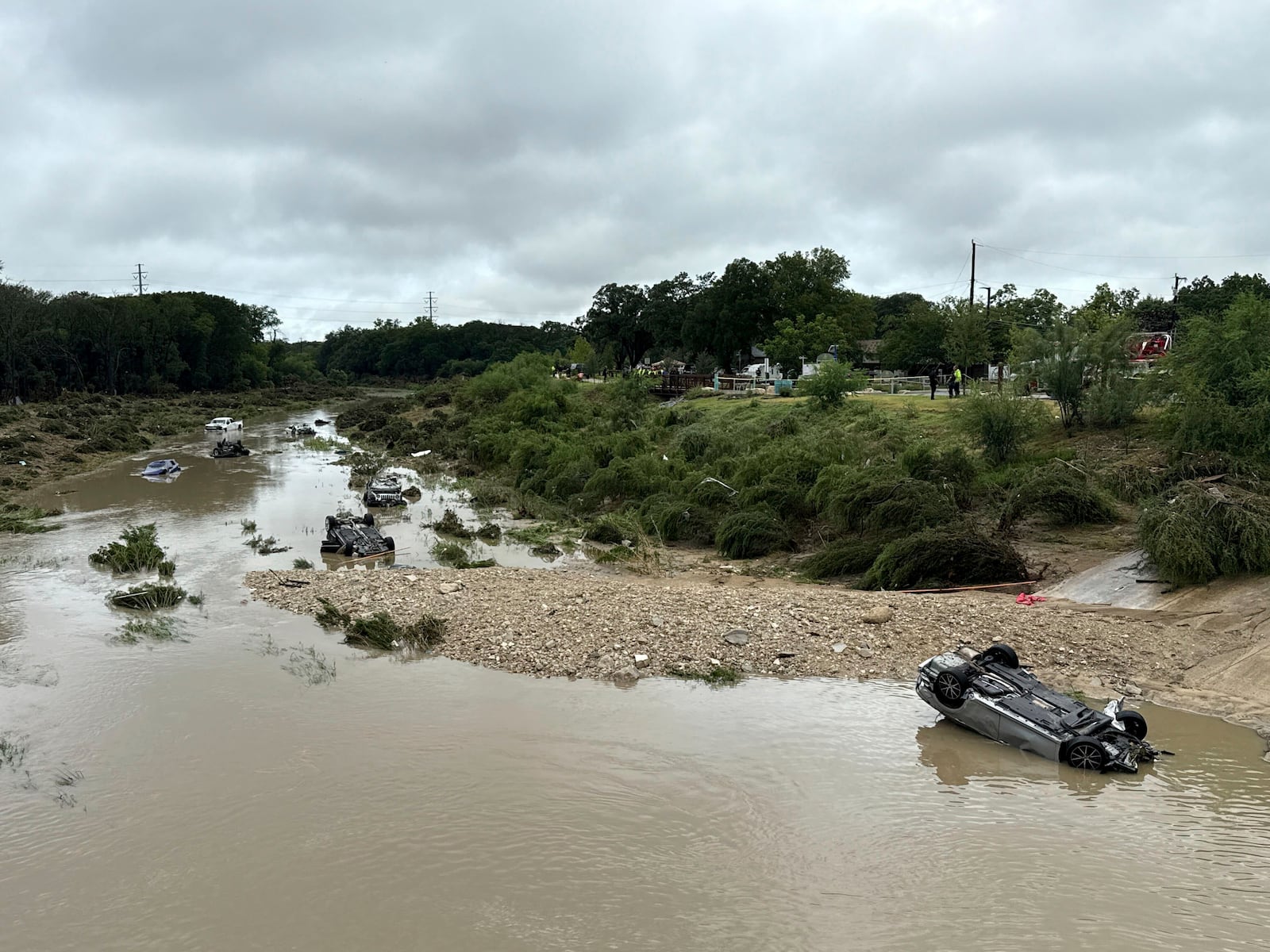 Vehicles sit in the river after being swept away by floodwaters in San Antonio, Tx., on Thursday, June 12, 2025. (AP Photo/Lekan Oyekanmi)