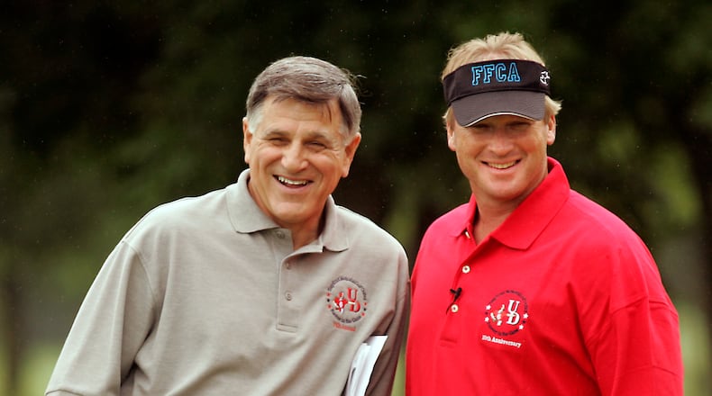 Former University of Dayton football coach Mike Kelly (left) and NFL TV analyst and former Super Bowl-winning coach Jon Gruden enjoy a light moment Friday on the golf course. Gruden lent celebrity to UD's annual golf outing, the Tony Ernst Memorial Golf Tournament at Yankee Trace.
