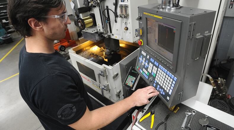 Matt Vanderbrock, a Wire EDM Programmer, runs one of many high tech machines at Noble Tool in Dayton. MARSHALL GORBY\STAFF