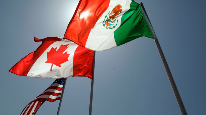 FILE - National flags representing the United States, Canada, and Mexico fly in the breeze in New Orleans where leaders of the North American Free Trade Agreement met on April 21, 2008. (AP Photo/Judi Bottoni, File)
