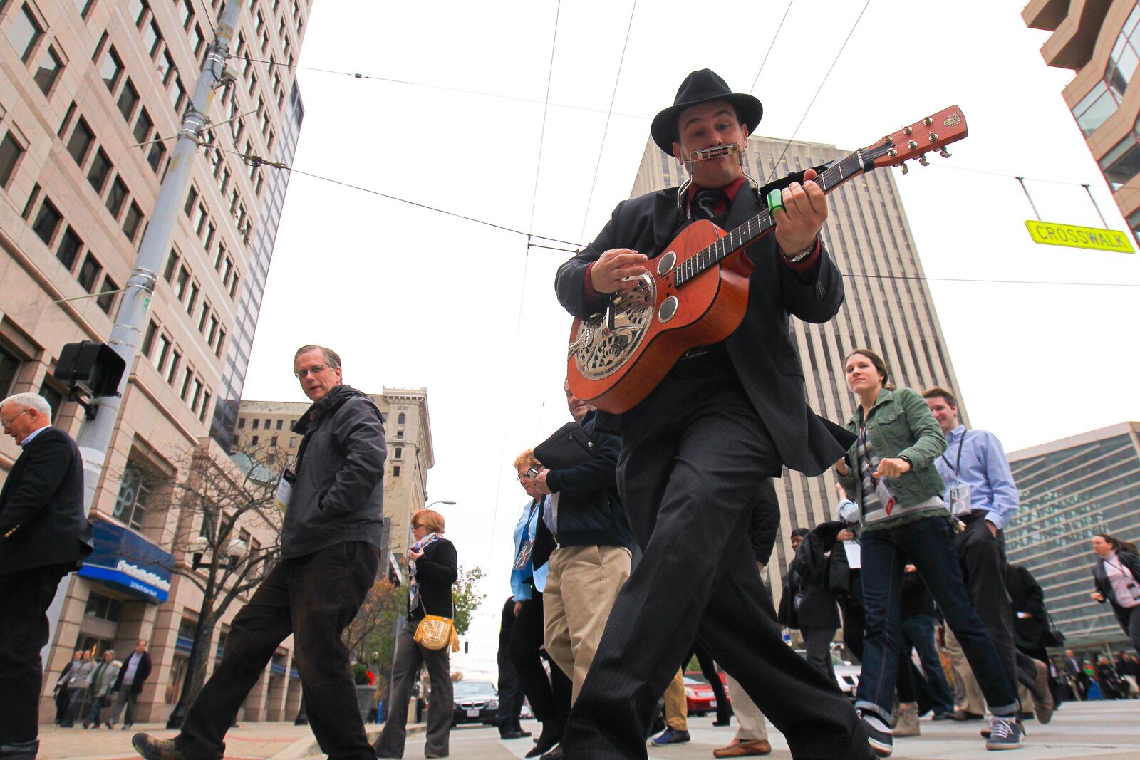 Todd the Fox plays guitar and harmonica as he leads TEDx attendees from a lunch break back to the Victoria Theatre. TEDx is a program of local, self-organized events that bring people together to share performances of diverse speakers and performers. Friday's local event is called TEDxDayton, where x = an independently organized TED event. JIM WITMER / STAFF