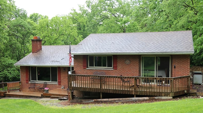 The brick quad-level is nestled among the rolling hills of the 3.69-acre property that is surrounded by a mature tree-line, a terraced lawn with patios and outbuildings, and a sitting area with a natural waterfall. Contributed