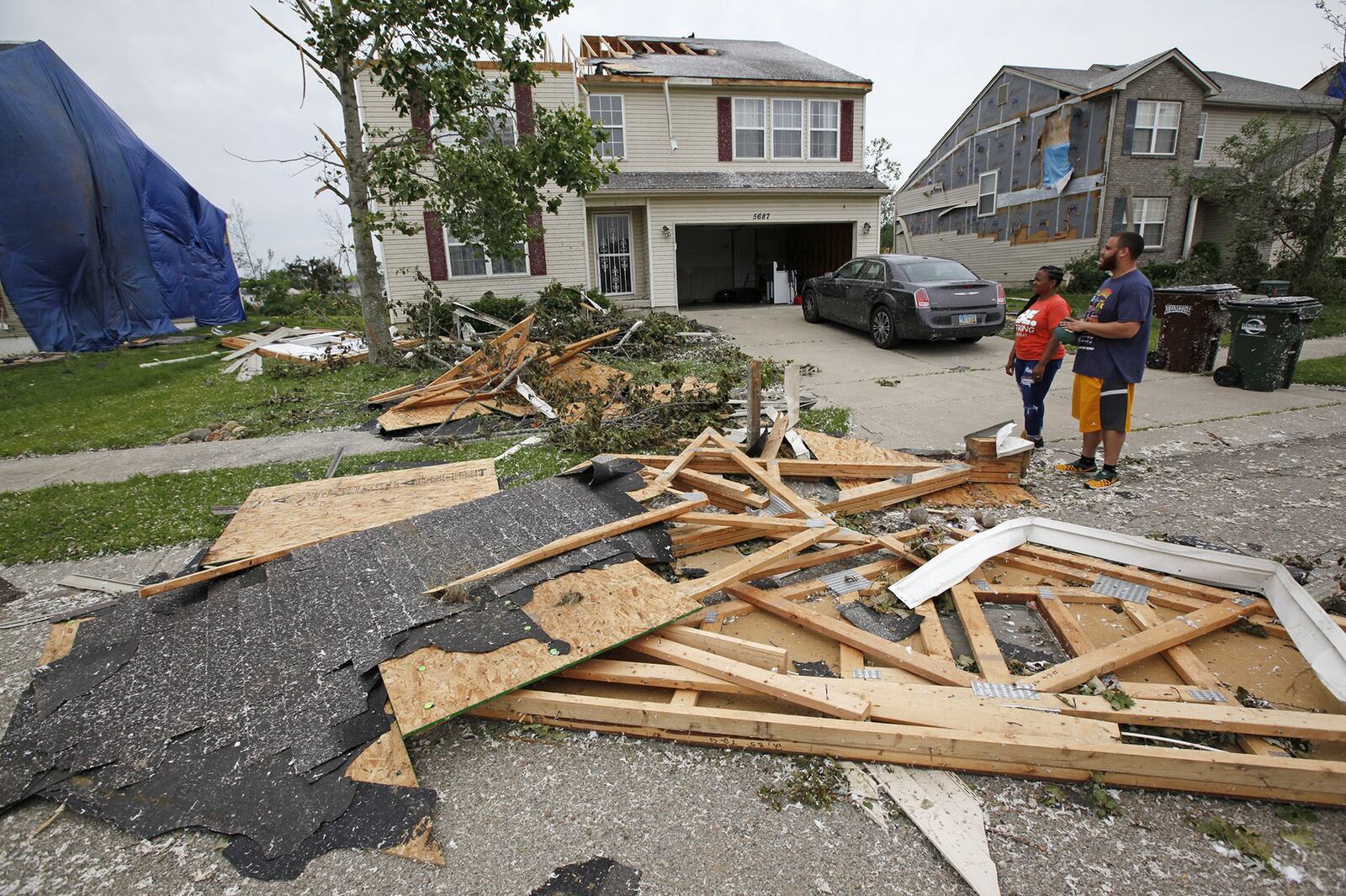 Trotwood residents Ryan an Danielle Johnson rode out the tornado in the basement on Monday night and discovered half of their roof missing on Wolf Creek Run. TY GREENLEES / STAFF