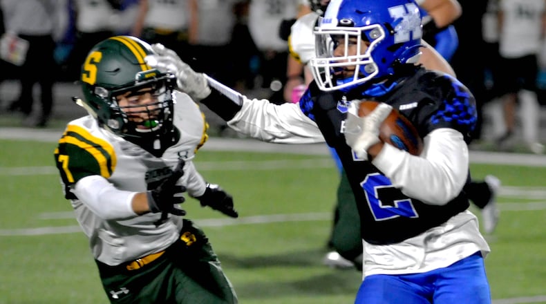 Hamilton's Semaj Aldridge, 2, fends off a Sycamore defender during the second quarter of a Greater Miami Conference game on Friday, Oct. 21. DAVID A. MOODIE/CONTRIBUTING PHOTOGRAPHER