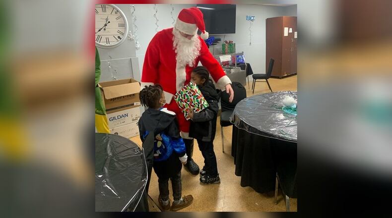 A Kettering Fairmont High School student dressed as Santa Claus to help deliver gifts to children. CONTRIBUTED