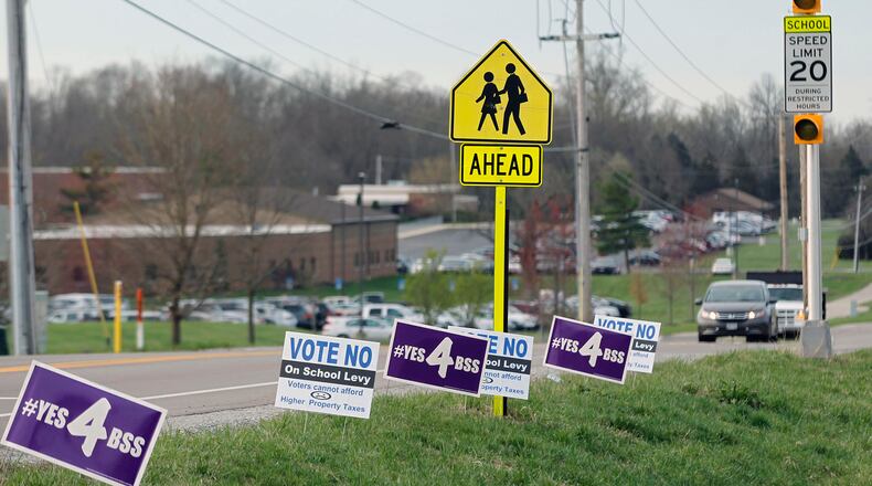 Levy campaign signs have popped up like spring flowers everywhere in Bellbrook, including this stretch at the corner of Upper Bellbrook and Feedwire Roads near Bellbrook High School. TY GREENLEES / STAFF