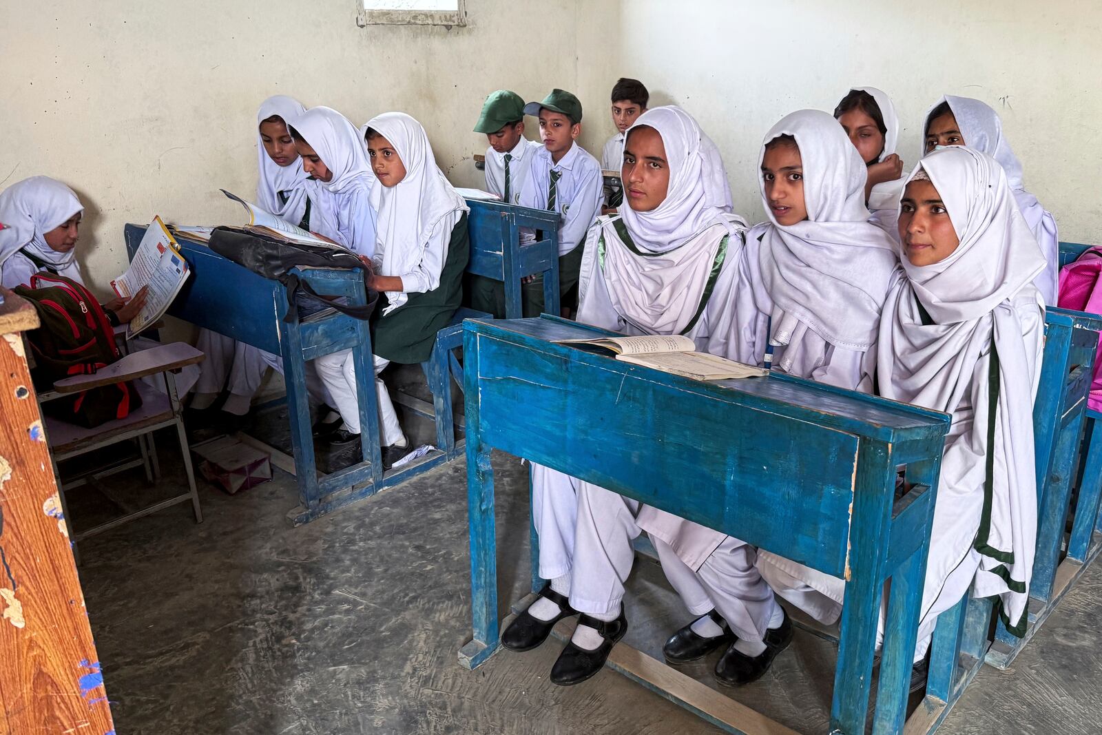 Students attend their class in Aligarh School and College of Commerce and Science in Dara Batang during a government's organized trip for media to Bella Noor Shah, a mountainous village near Muzaffarabad, the capital of Pakistan administered Kashmir, Monday, May 5, 2025. (AP Photo/Muhammad Yousuf, Pool)